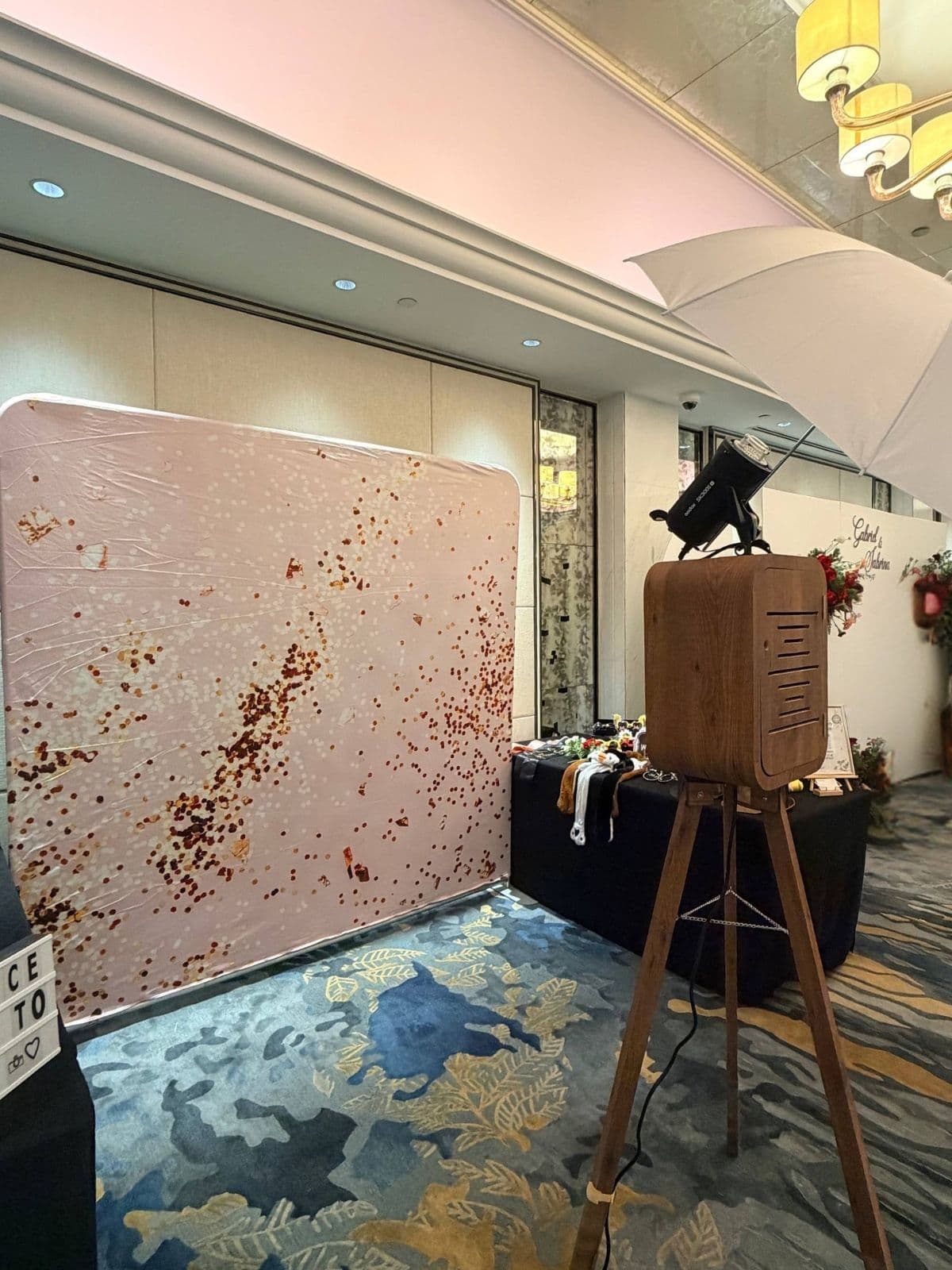 Photobooth rental setup with blush backdrop and props table